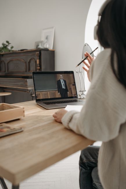 Person attending an online class with a laptop and headphones