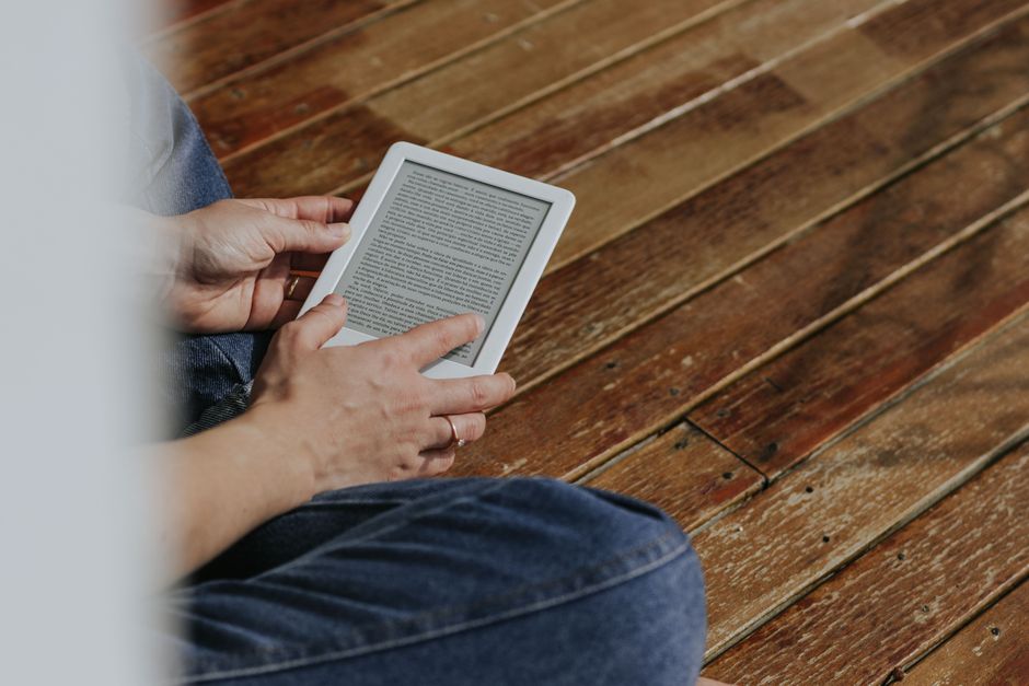 Hands holding an e-reader while reading