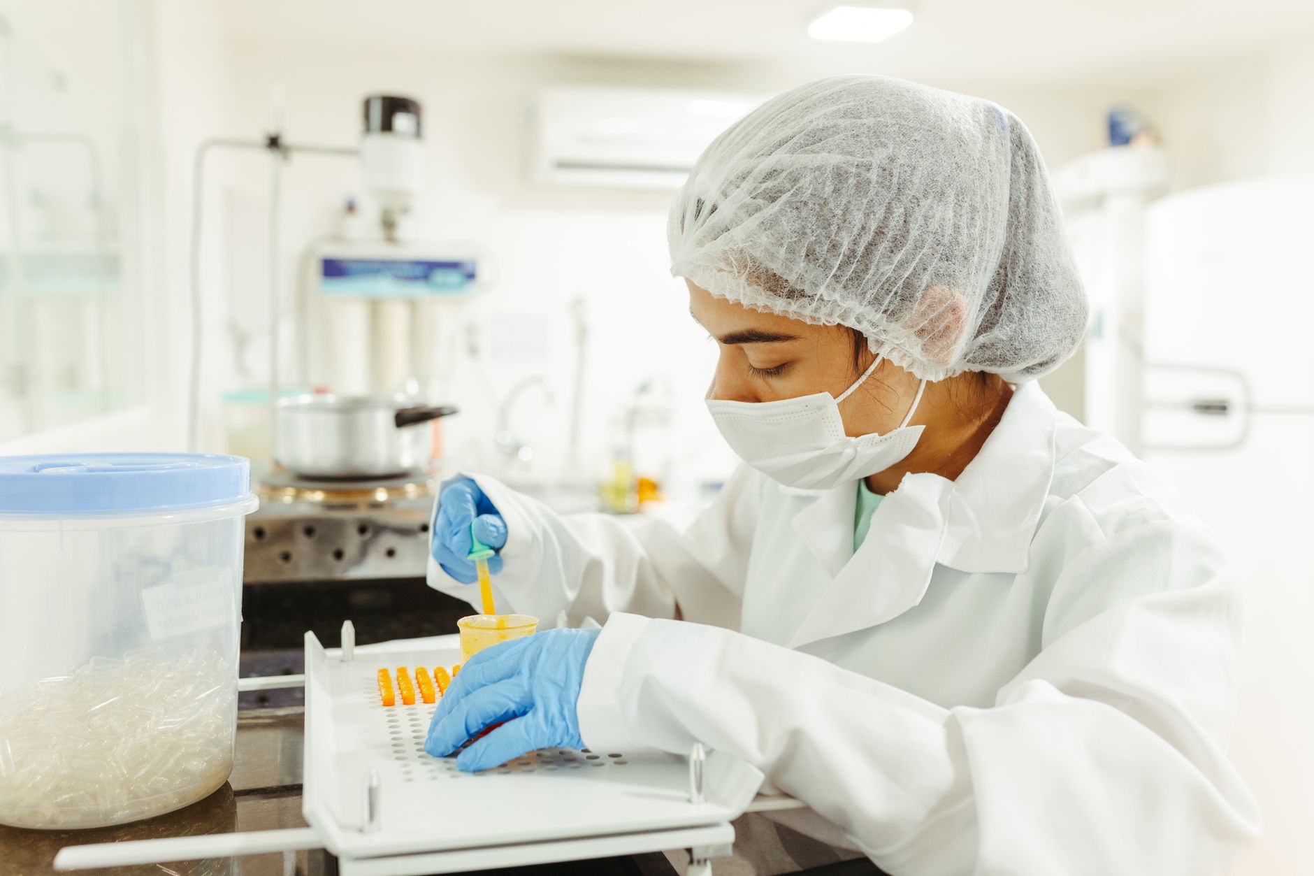 Scientist in protective gear performing a lab experiment