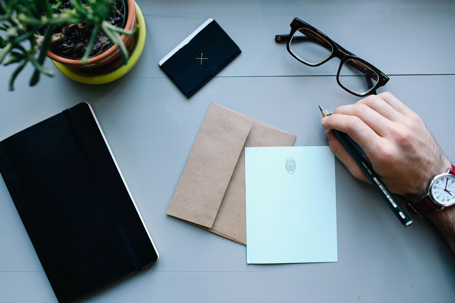 Desk with writing tools, glasses, and notebooks