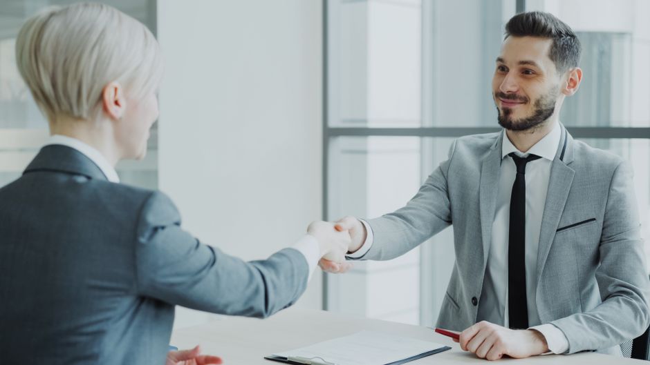Two professionals shaking hands in a modern office