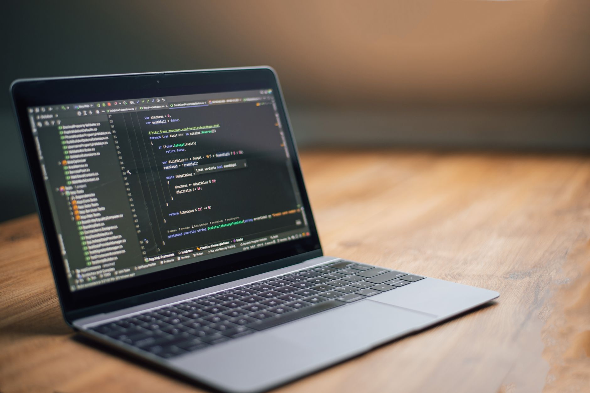 Laptop displaying code on a wooden desk