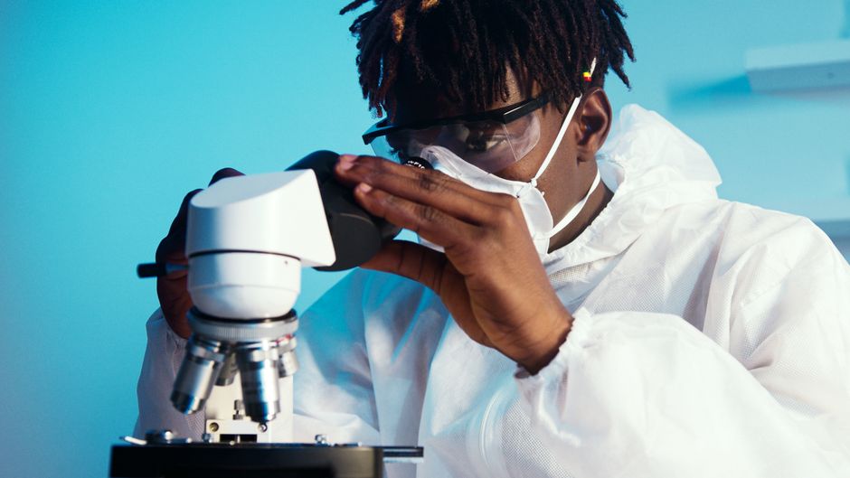 Scientist examining samples through a microscope in a laboratory