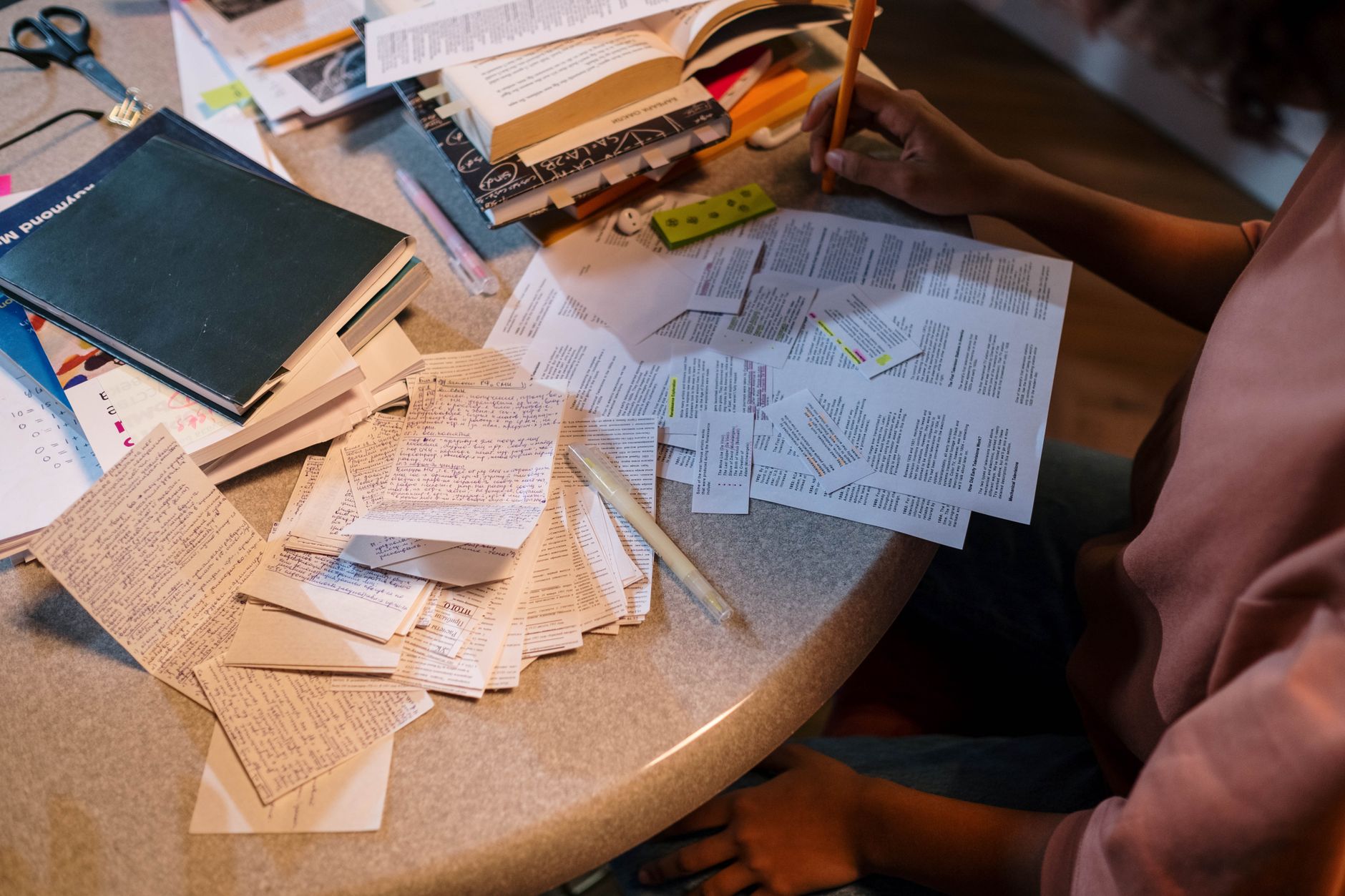 Student organizing notes and books at a desk