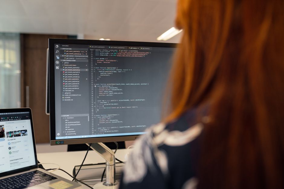 Software engineer coding on a computer in a modern office