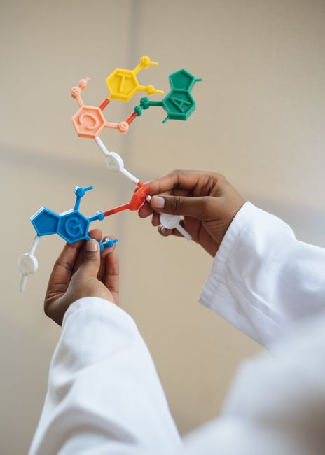 Scientist in a lab coat examining a molecular model